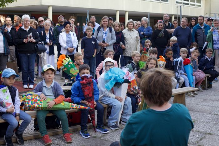 Eltern und Kinder versammelt am ersten Schultag
