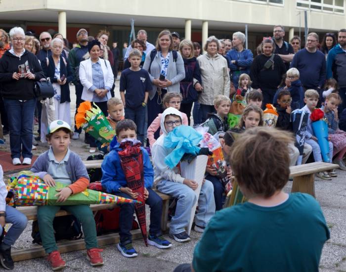 Eltern und Kinder versammelt am ersten Schultag